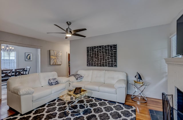 living room featuring hardwood / wood-style floors and ceiling fan with notable chandelier