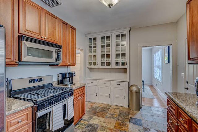 kitchen featuring appliances with stainless steel finishes and light stone counters