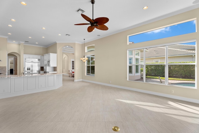 unfurnished living room with ceiling fan, light tile patterned flooring, sink, and crown molding