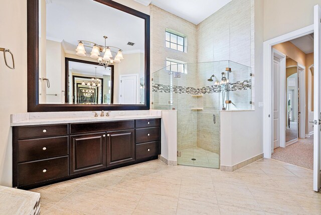 bathroom featuring vanity, an inviting chandelier, an enclosed shower, and crown molding