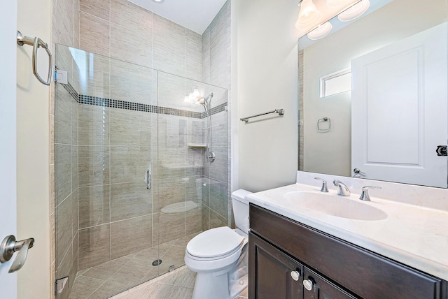 bathroom featuring tile patterned flooring, vanity, toilet, and a shower with door