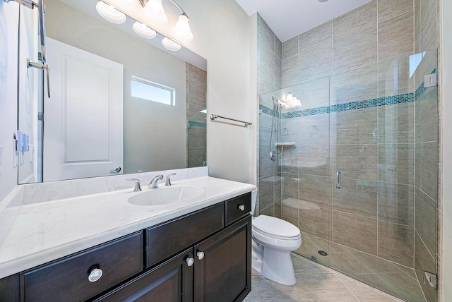 bathroom featuring tile patterned flooring, vanity, an enclosed shower, and toilet