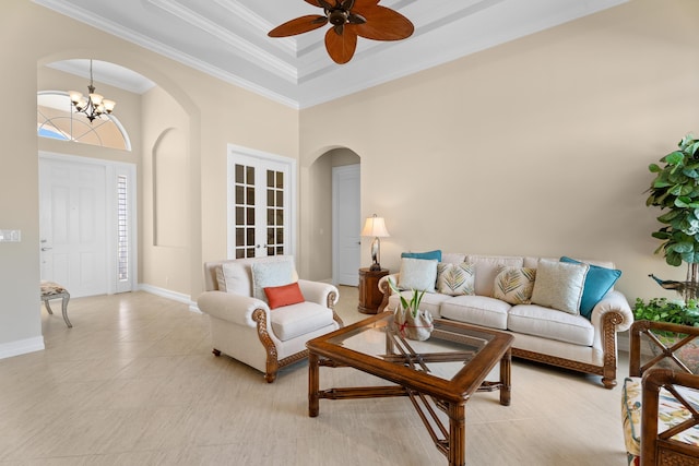 tiled living room featuring a high ceiling, ceiling fan with notable chandelier, and ornamental molding