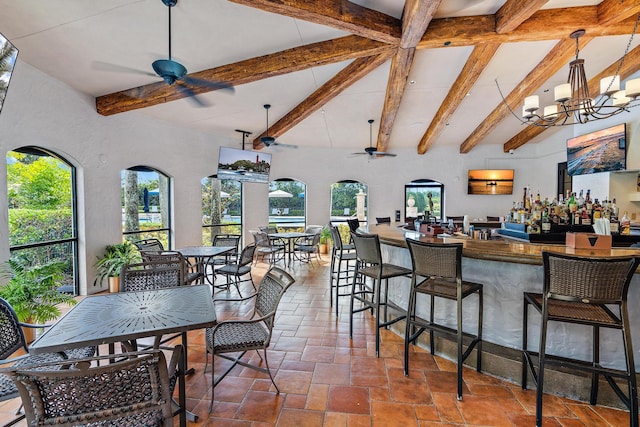 interior space with ceiling fan with notable chandelier, beam ceiling, and decorative light fixtures