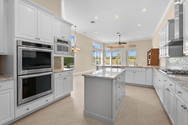 kitchen featuring light stone countertops, a textured ceiling, appliances with stainless steel finishes, tasteful backsplash, and decorative light fixtures