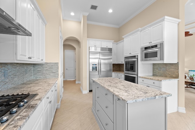 kitchen featuring wall chimney range hood, ornamental molding, a textured ceiling, kitchen peninsula, and stainless steel appliances