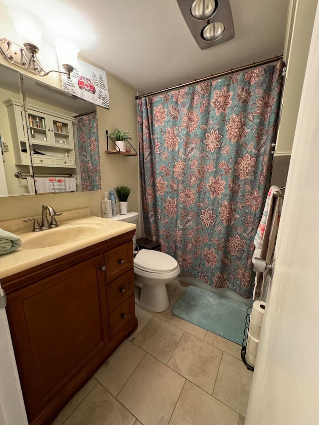 bathroom with tile flooring, toilet, and vanity