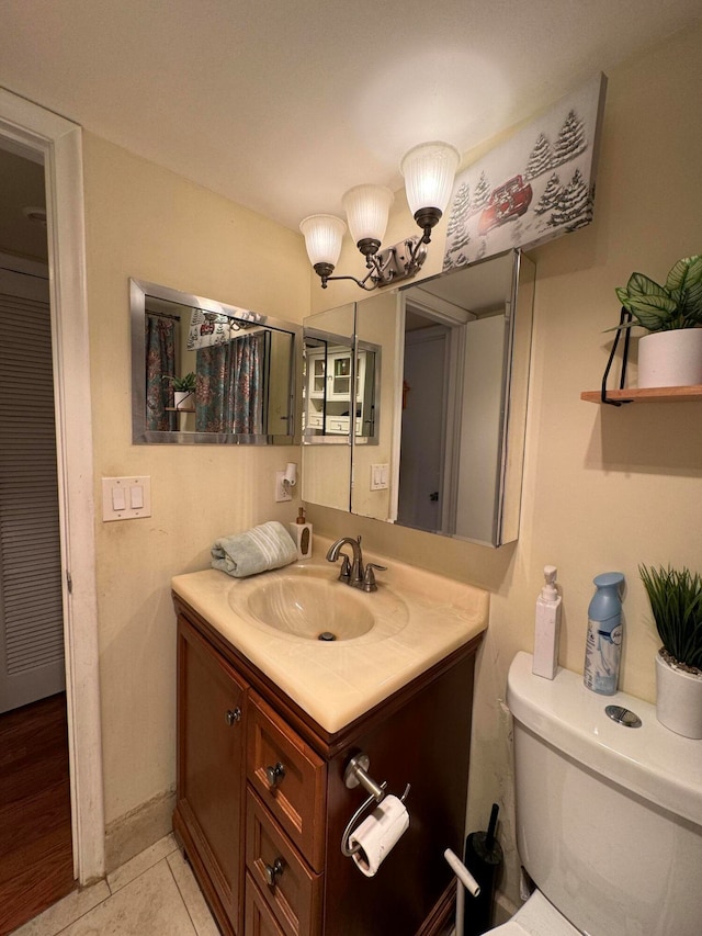 bathroom with toilet, tile floors, and large vanity