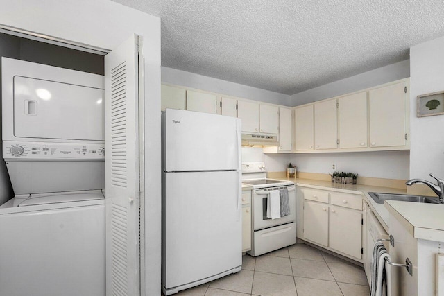 kitchen with white appliances, sink, cream cabinetry, stacked washer and dryer, and light tile patterned flooring