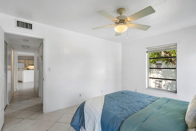 tiled bedroom featuring ceiling fan and a textured ceiling