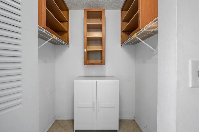 spacious closet with light tile patterned flooring