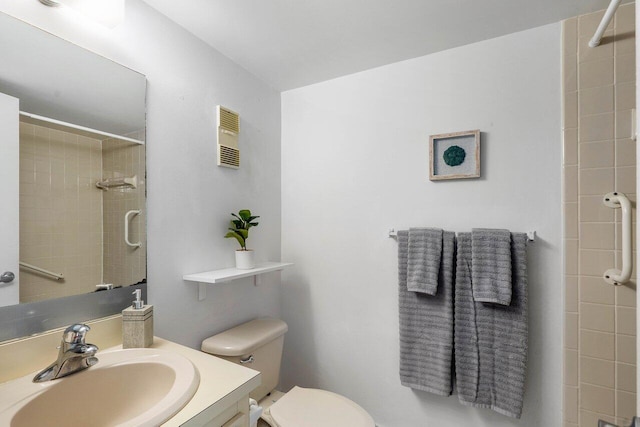 bathroom featuring vanity, toilet, and a tile shower