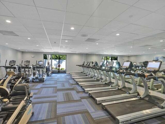 exercise room featuring a drop ceiling and carpet