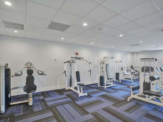 gym with a paneled ceiling and carpet