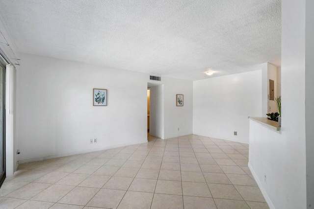 tiled empty room with a textured ceiling