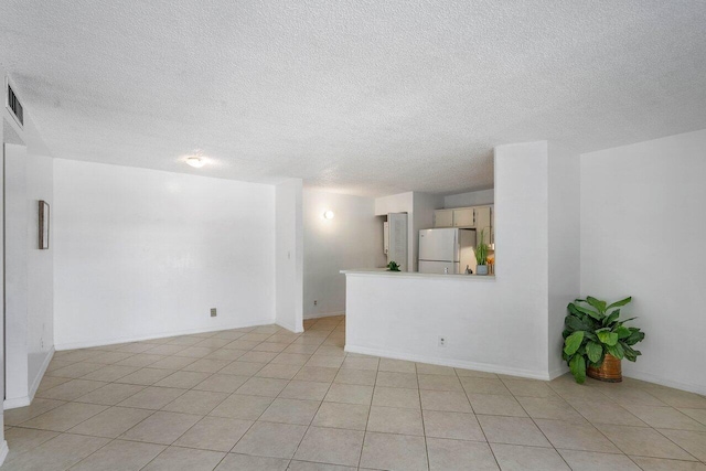 tiled spare room with a textured ceiling