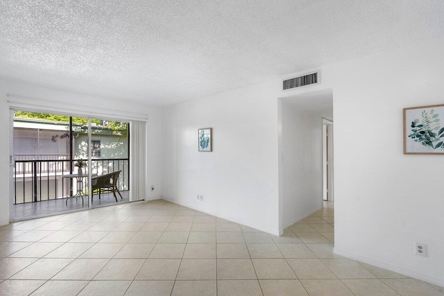 tiled spare room featuring a textured ceiling