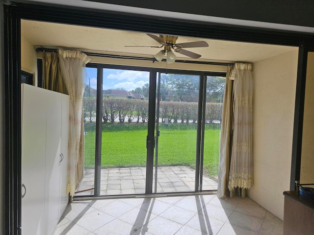 doorway to outside featuring light tile patterned floors and ceiling fan