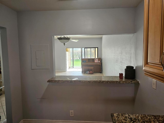 kitchen with tile patterned floors, electric panel, and stone countertops