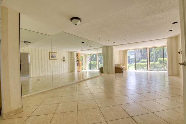 spare room with a textured ceiling and light tile patterned floors