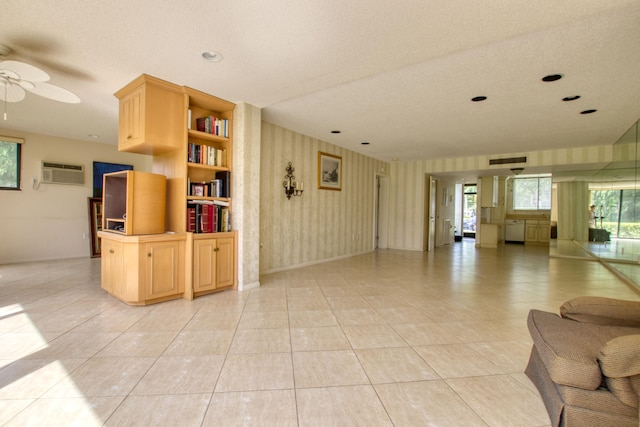 tiled living room with an AC wall unit, a textured ceiling, and ceiling fan