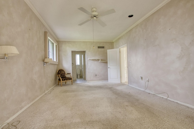 spare room featuring crown molding, light colored carpet, and ceiling fan