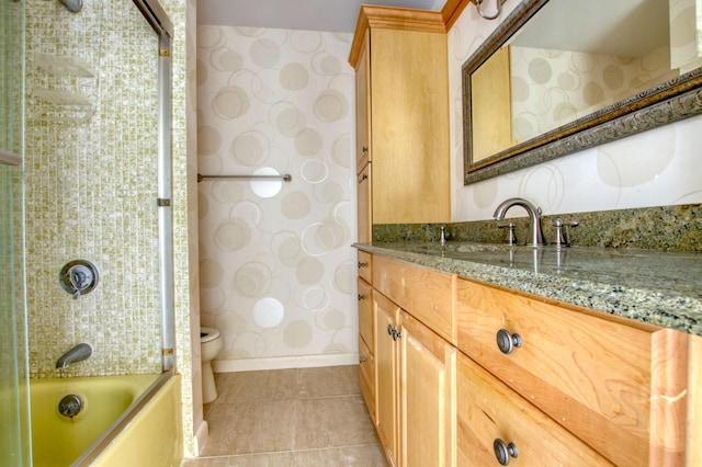 full bathroom featuring tile patterned flooring, vanity, tiled shower / bath, and toilet