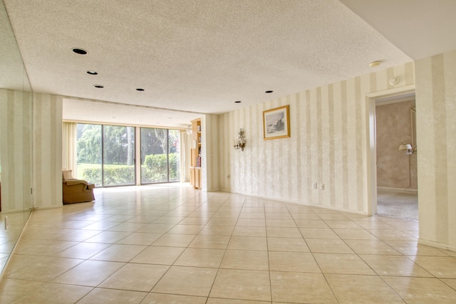 empty room with a textured ceiling and light tile patterned floors