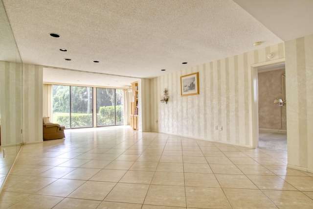 spare room with a textured ceiling and light tile patterned floors