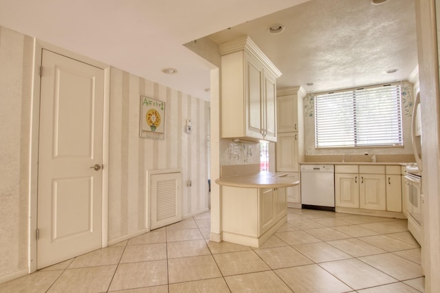 kitchen with light tile patterned flooring, cream cabinets, white appliances, sink, and a kitchen island