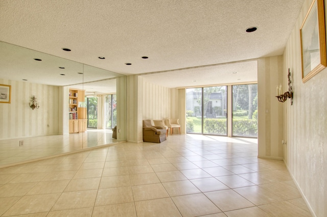 tiled empty room with a textured ceiling and a healthy amount of sunlight