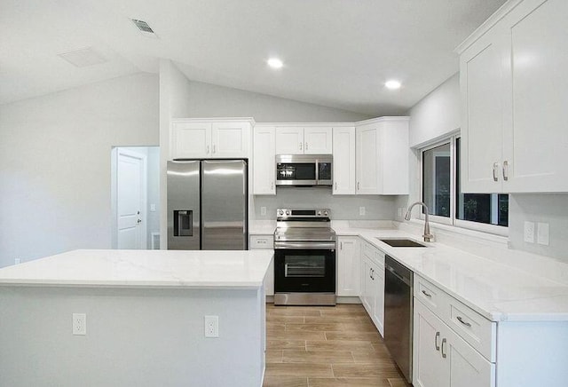 kitchen featuring a kitchen island, stainless steel appliances, white cabinets, and sink