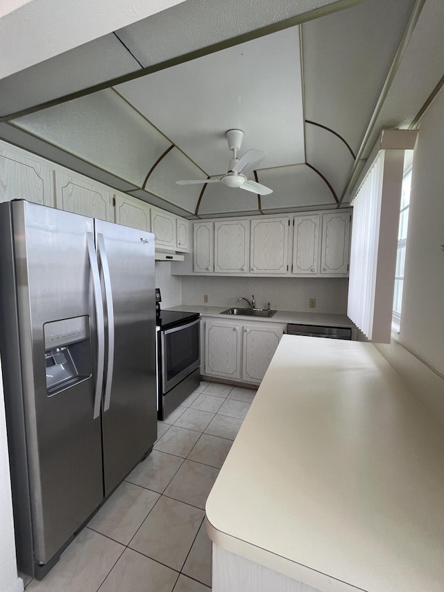 kitchen with appliances with stainless steel finishes, sink, ceiling fan, and light tile floors