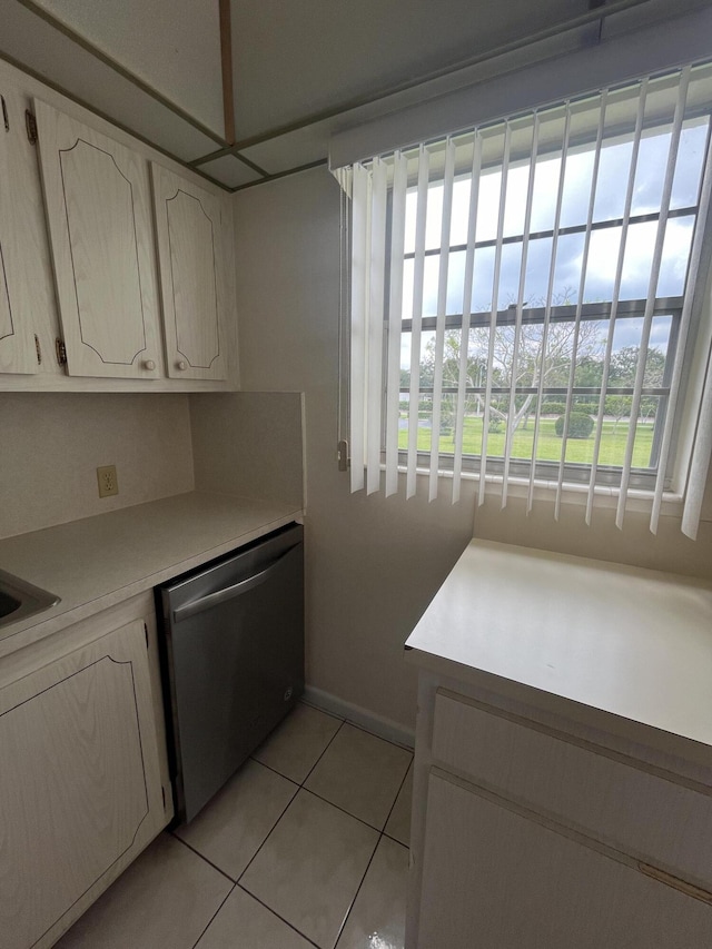 kitchen featuring dishwasher, plenty of natural light, and light tile floors