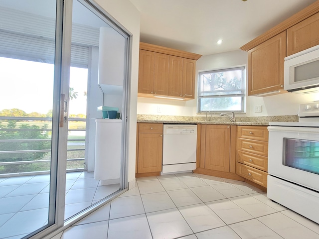 kitchen featuring sink, white appliances, light stone countertops, and light tile flooring