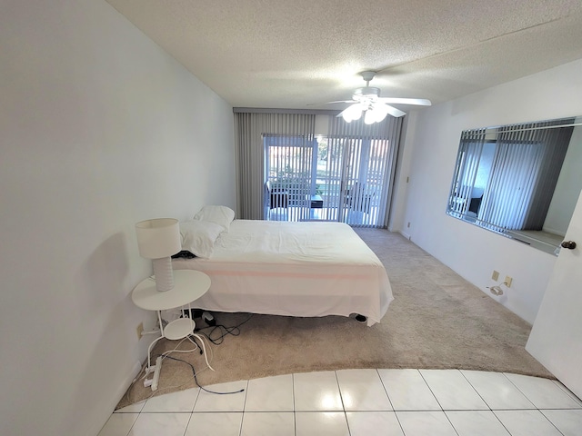 bedroom featuring ceiling fan, light tile flooring, and a textured ceiling