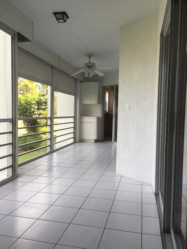 unfurnished room with ceiling fan, light tile floors, and a wealth of natural light