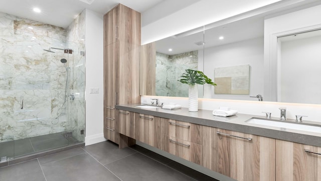 bathroom featuring a shower with shower door, vanity with extensive cabinet space, dual sinks, and tile flooring