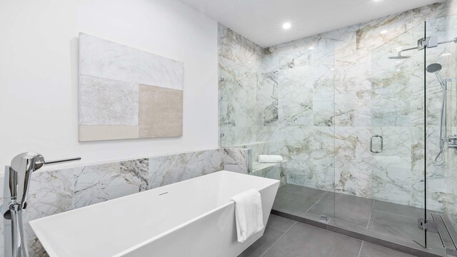 bathroom with tile walls, tile flooring, and independent shower and bath