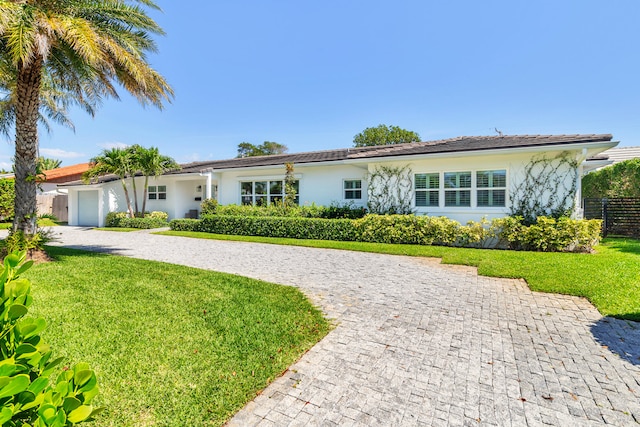 ranch-style house with a garage and a front yard