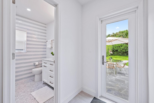 entryway with light tile floors and tile walls