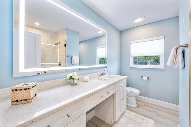 bathroom featuring hardwood / wood-style floors, toilet, and vanity with extensive cabinet space