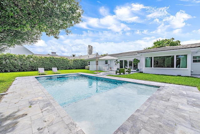 view of pool featuring a yard and a patio