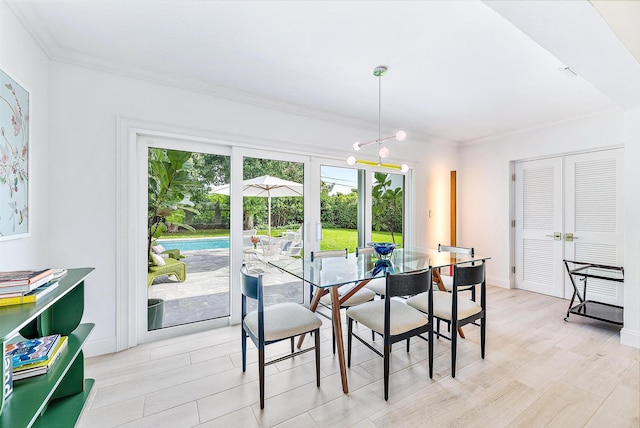 dining area featuring ornamental molding, light hardwood / wood-style floors, and an inviting chandelier