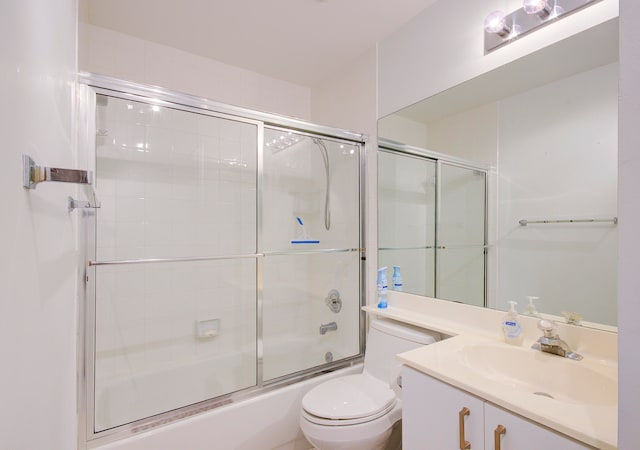 full bathroom featuring enclosed tub / shower combo, vanity, and toilet