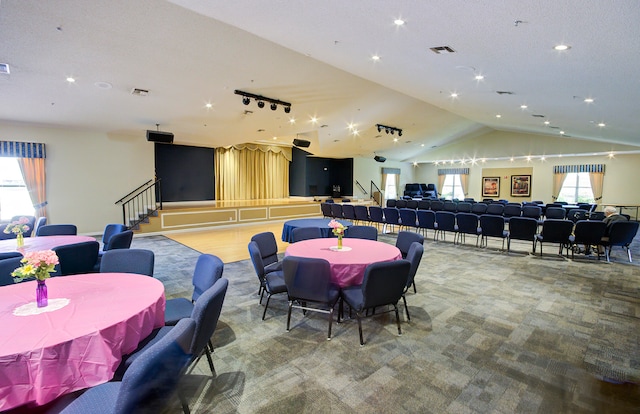 carpeted dining room featuring lofted ceiling