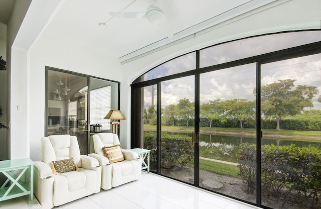 sunroom with a water view and ceiling fan