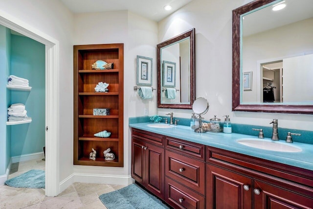 bathroom featuring large vanity, tile floors, and dual sinks