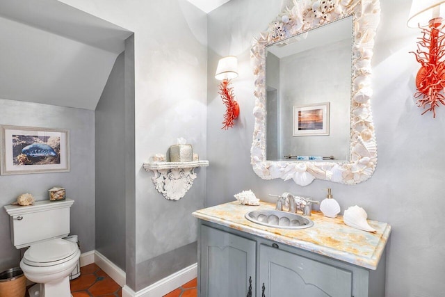 bathroom featuring tile flooring, lofted ceiling, vanity, and toilet