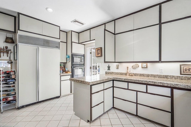 kitchen featuring light tile floors and black appliances